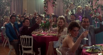 Movie still from “The Wedding Singer” (1998), directed by Frank Coraci – A group of people sitting around a table with wine glasses; Wide shot, Low angle
