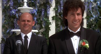 Movie still from “The Wedding Singer” (1998), directed by Frank Coraci – A couple of men standing next to each other in tuxedos; Medium shot, Low angle