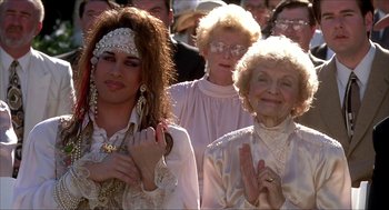 Movie still from “The Wedding Singer” (1998), directed by Frank Coraci – A group of people standing next to each other in a crowd; Medium shot, High angle