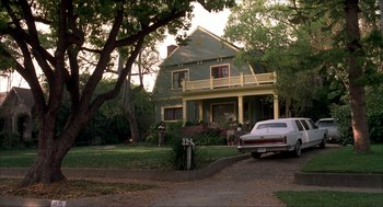 Movie still from “The Wedding Singer” (1998), directed by Frank Coraci – An old car is parked in front of a house; Extreme Wide shot, Low angle