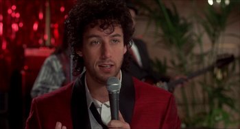 Movie still from “The Wedding Singer” (1998), directed by Frank Coraci – A man in a red jacket is holding a microphone; Close Up shot, Over the shoulder angle