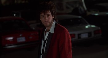 Movie still from “The Wedding Singer” (1998), directed by Frank Coraci – A man in a red jacket standing in a parking lot; Close Up shot, Low angle