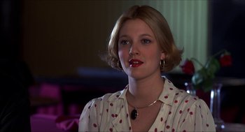 Movie still from “The Wedding Singer” (1998), directed by Frank Coraci – A young woman wearing a polka dot shirt and wearing a necklace; Close Up shot, Over the shoulder angle