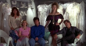 Movie still from “The Wedding Singer” (1998), directed by Frank Coraci – A group of people sitting and standing in a room; Wide shot, Over the shoulder angle