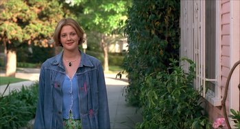 Movie still from “The Wedding Singer” (1998), directed by Frank Coraci – A woman standing on a sidewalk in front of a building; Medium shot, Over the shoulder angle