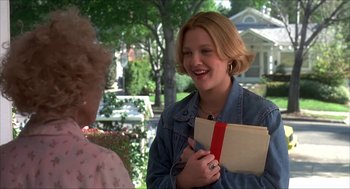 Movie still from “The Wedding Singer” (1998), directed by Frank Coraci – A woman holding an envelope talking to another woman; Medium shot, High angle