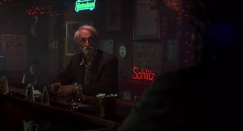 Movie still from “The Wedding Singer” (1998), directed by Frank Coraci – An older man sitting at a bar with a beer; Medium shot, Over the shoulder angle