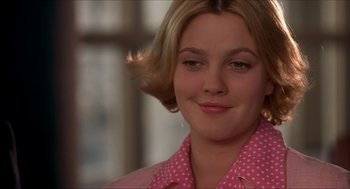 Movie still from “The Wedding Singer” (1998), directed by Frank Coraci – A young woman in a pink polka dot shirt looks to her left; Close Up shot, Over the shoulder angle