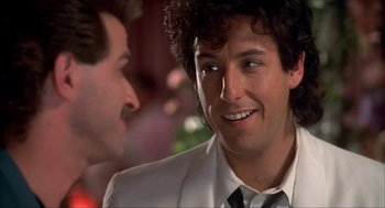 Movie still from “The Wedding Singer” (1998), directed by Frank Coraci – A man in a white suit and a black tie; Close Up shot, Over the shoulder angle