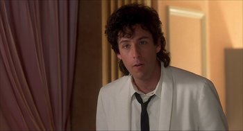 Movie still from “The Wedding Singer” (1998), directed by Frank Coraci – A man in a white suit and a black tie; Close Up shot, Over the shoulder angle
