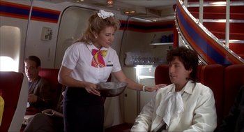 Movie still from “The Wedding Singer” (1998), directed by Frank Coraci – A flight attendant handing a bowl to a passenger; Medium shot, Low angle