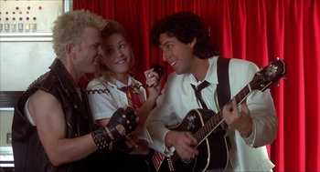 Movie still from “The Wedding Singer” (1998), directed by Frank Coraci – A group of young people singing and playing guitars; Medium shot, Over the shoulder angle