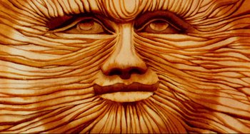 Movie still from “The Wicker Man” (1973), directed by Robin Hardy – Image of the face of a person carved out of wood; Extreme Close Up shot, Overhead angle