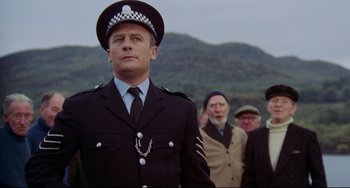 Movie still from “The Wicker Man” (1973), directed by Robin Hardy – A group of men standing next to each other; Medium shot, Low angle