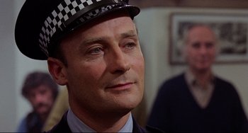 Movie still from “The Wicker Man” (1973), directed by Robin Hardy – A person wearing a hat; Close Up shot, Over the shoulder angle