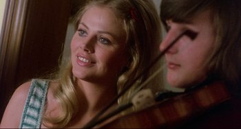 Movie still from “The Wicker Man” (1973), directed by Robin Hardy – A beautiful young blonde woman holding a violin; Close Up shot, Over the shoulder angle