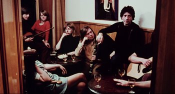 Movie still from “The Wicker Man” (1973), directed by Robin Hardy – A group of people sitting around a table with wine glasses; Medium shot, High angle