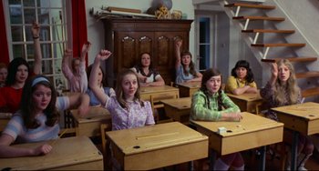 Movie still from “The Wicker Man” (1973), directed by Robin Hardy – A group of young girls sitting at desks in a classroom; Medium shot, High angle