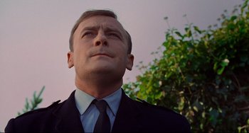 Movie still from “The Wicker Man” (1973), directed by Robin Hardy – A person wearing a suit and tie; Close Up shot, Low angle