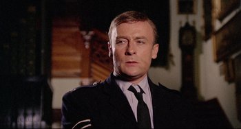 Movie still from “The Wicker Man” (1973), directed by Robin Hardy – A person wearing a suit and tie; Close Up shot, Low angle