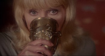 Movie still from “The Wicker Man” (1973), directed by Robin Hardy – A woman drinking from a gold cup; Close Up shot, Over the shoulder angle