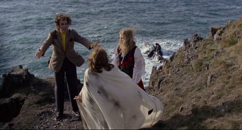 Movie still from “The Wicker Man” (1973), directed by Robin Hardy – Two women and a man on a cliff near the ocean; Wide shot, High angle