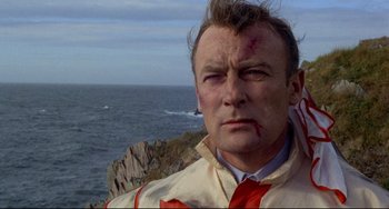 Movie still from “The Wicker Man” (1973), directed by Robin Hardy – A person near a body of water; Close Up shot, Low angle