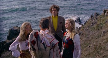Movie still from “The Wicker Man” (1973), directed by Robin Hardy – A group of people standing on top of a cliff near the ocean; Medium shot, High angle