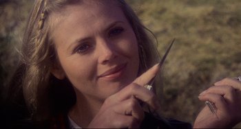 Movie still from “The Wicker Man” (1973), directed by Robin Hardy – A woman holding a pair of scissors in her hand; Close Up shot, Over the shoulder angle