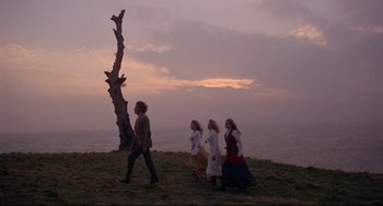 Movie still from “The Wicker Man” (1973), directed by Robin Hardy – A group of people walking on the beach at sunset; Wide shot, Low angle