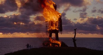 Movie still from “The Wicker Man” (1973), directed by Robin Hardy – A fire is burning in the middle of the ocean; Extreme Wide shot, Low angle