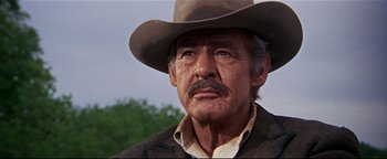 Movie still from “The Wild Bunch” (1969), directed by Sam Peckinpah – An older man wearing a cowboy hat looking at the camera; Close Up shot, Low angle