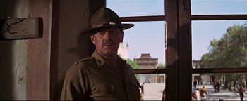 Movie still from “The Wild Bunch” (1969), directed by Sam Peckinpah – An older man wearing a hat in front of an open window; Medium shot, Low angle