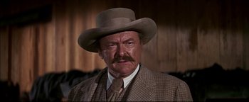 Movie still from “The Wild Bunch” (1969), directed by Sam Peckinpah – An older man wearing a hat and a suit; Close Up shot, Low angle