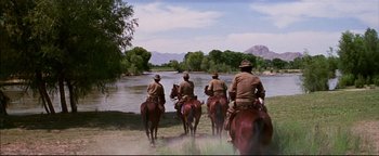 Movie still from “The Wild Bunch” (1969), directed by Sam Peckinpah – A group of men riding horses across a river; Wide shot, Low angle