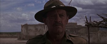 Movie still from “The Wild Bunch” (1969), directed by Sam Peckinpah – An older man wearing a hat and a uniform looks at the camera; Close Up shot, Low angle
