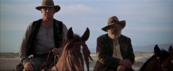 Movie still from “The Wild Bunch” (1969), directed by Sam Peckinpah – Two men sitting on top of a brown horse; Medium shot, Low angle