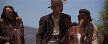 Movie still from “The Wild Bunch” (1969), directed by Sam Peckinpah – A man wearing a cowboy hat sitting on top of a horse; Medium shot, Low angle