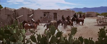 Movie still from “The Wild Bunch” (1969), directed by Sam Peckinpah – A group of men on horses in front of an adobe building; Extreme Wide shot, Low angle