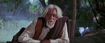 Movie still from “The Wild Bunch” (1969), directed by Sam Peckinpah – An old man with a white beard sitting on a chair; Medium shot, High angle