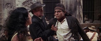 Movie still from “The Wild Bunch” (1969), directed by Sam Peckinpah – A man and a man with a hat on; Medium shot, Over the shoulder angle