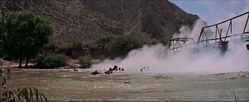 Movie still from “The Wild Bunch” (1969), directed by Sam Peckinpah – A group of people on horses in a body of water; Extreme Wide shot, High angle