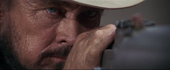 Movie still from “The Wild Bunch” (1969), directed by Sam Peckinpah – A man's face with his hand on his face; Extreme Close Up shot, Low angle