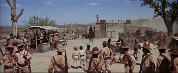 Movie still from “The Wild Bunch” (1969), directed by Sam Peckinpah – A group of people standing in a dirt field; Extreme Wide shot, Low angle