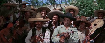 Movie still from “The Wild Bunch” (1969), directed by Sam Peckinpah – A group of men wearing hats and smiling for a picture; Medium shot, High angle