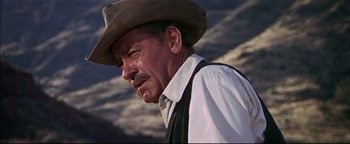 Movie still from “The Wild Bunch” (1969), directed by Sam Peckinpah – An older man wearing a cowboy hat and a white shirt; Close Up shot, Over the shoulder angle