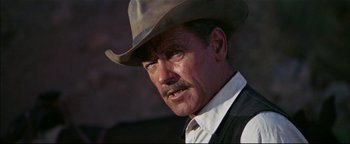 Movie still from “The Wild Bunch” (1969), directed by Sam Peckinpah – An older man wearing a cowboy hat and a vest; Close Up shot, Low angle
