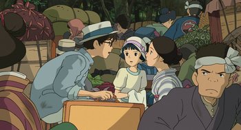 Movie still from “The Wind Rises” (2013), directed by Hayao Miyazaki – A group of people gathered around a young girl; Medium shot, Over the shoulder angle