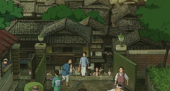 Movie still from “The Wind Rises” (2013), directed by Hayao Miyazaki – An illustration of people standing in front of a building; Extreme Wide shot, High angle