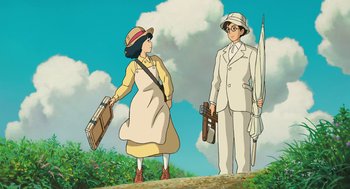 Movie still from “The Wind Rises” (2013), directed by Hayao Miyazaki – A woman and a man standing next to each other holding suitcases; Medium shot, Low angle
